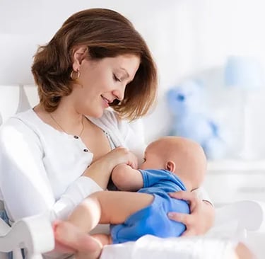 a woman breastfeeding a baby in a rocking chair