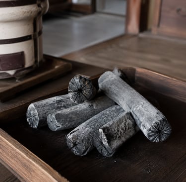 Traditional Japanese Bincho charcoal logs on a wooden tray for a Shichirin hibachi grill.