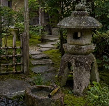 Traditional Japanese garden with a stone lantern, water basin, and mossy stone path.