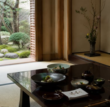 Traditional Japanese kaiseki meal served on a dark wood table in a washitsu room overlooking a zen garden.