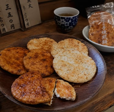 Crispy Japanese senbei rice crackers served on a wooden plate with green tea.