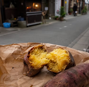 Roasted Japanese sweet potato yaki-imo broken open on brown paper in a Tokyo street.