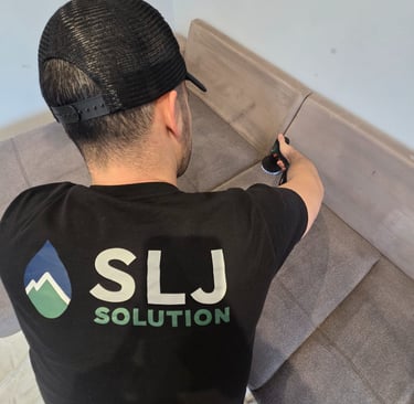 Technicien SLJ Solution en train de nettoyer un canapé à Grenoble avec un injecteur-extracteur profe