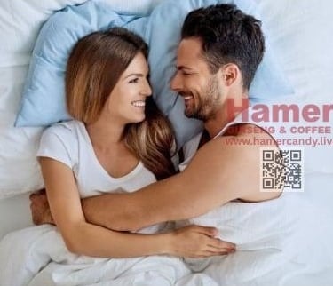 a man and woman are smiling and hugging in bed hamer candy