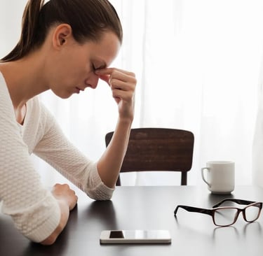 a woman sitting at a table with a cell phone