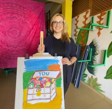 a woman holding a painting of a house