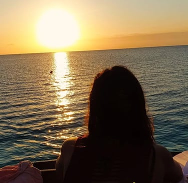 Silhouettes of tourists enjoying the serene Zanzibar sunset on a traditional dhow cruise.