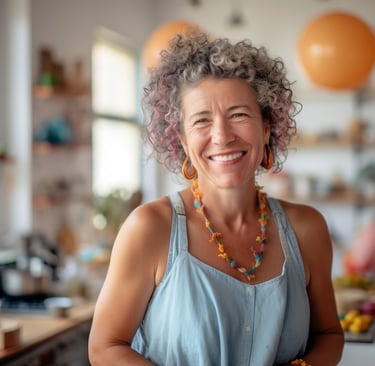 Woman with a curly hair in her kitchen, with balloons in the background.
