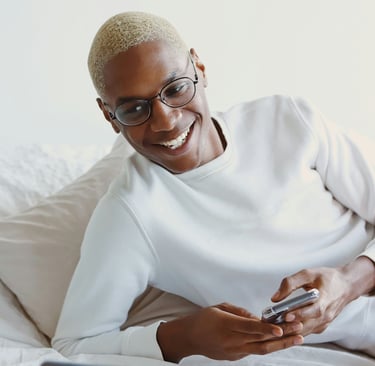 Black person playing with mobile phone and smiling.