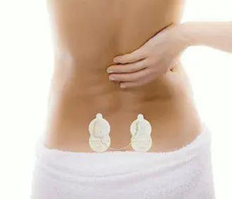 Woman holding her back in pain with Painmaster Patches applied to lower back.