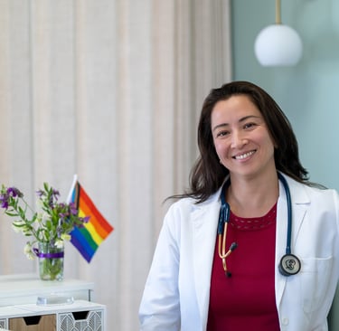 Dr Shannon Connolly in a white coat at the front desk of Open Arms Primary Care
