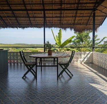 Open-air teahouse at Loei Valley with grass roof and orchard views