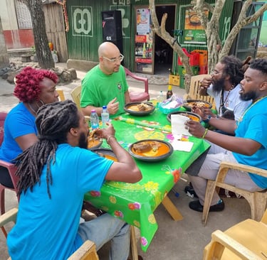 Sankofa Flamingo in Ahanta, Ghana, sitting around a table eating