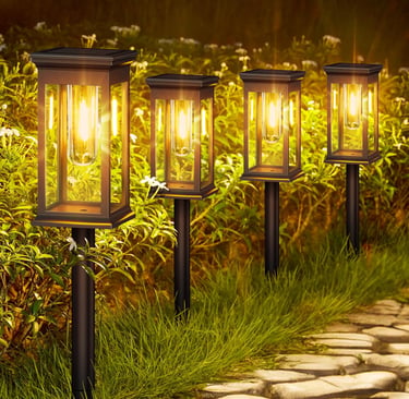 Set of four warm LED solar pathway lights illuminating a stone garden walkway at night.
