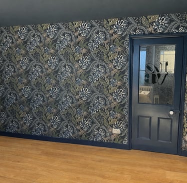 Sussex room featuring dark blue doors and tropical botanical wallpaper with palm leaf patterns.