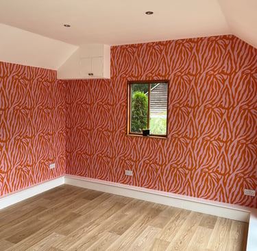 Bold red and pink zebra print wallpaper and light oak laminate flooring in Sussex.