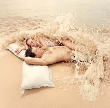 a man and woman laying on a pillow on Samui beach