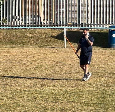 Referee checking the playing urface of a rugby field.
