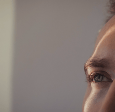 Un regard en gros plan dont la pupille capte une lumière faible