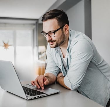 man checking payments on laptop