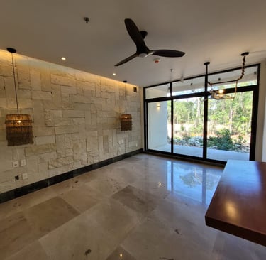 Imagen de espacio al interior de una casa remodelada con muros de piedra natural, pisos de mármol y ventanas de piso a techo