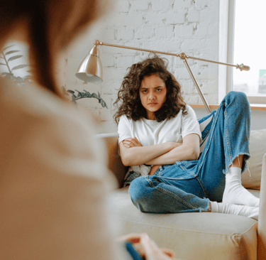 Photo d'une adolescente boudeuse sur un canapé