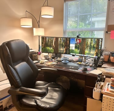 A creative office with a computer, desk chair, and art supplies.