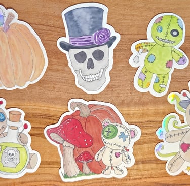 Watercolor voodoo doll and skull stickers against a wood background.