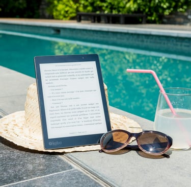 a tablet with a straw hat and sunglasses next to a pool