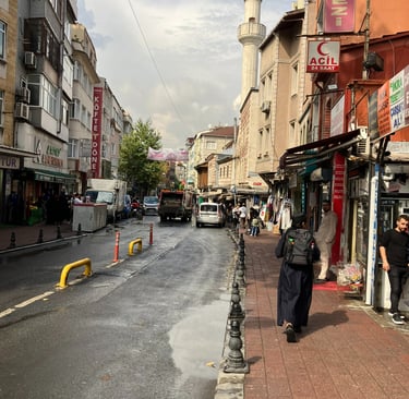 a man walking down a street in istanbul with a car parked on the side of the road