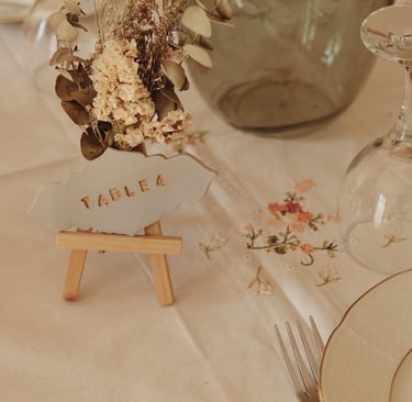 Numéro de table en argile sur chevalet avec fleurs séchées 
