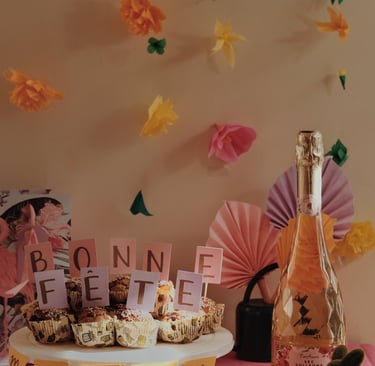 Bonne fête maman sur des muffins avec des fleurs flottantes en arrière plan et une bouteille