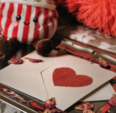 Heart card on a plate with rose petals and pop corn plush