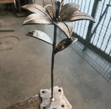 a metal flower sculpture on a wooden table