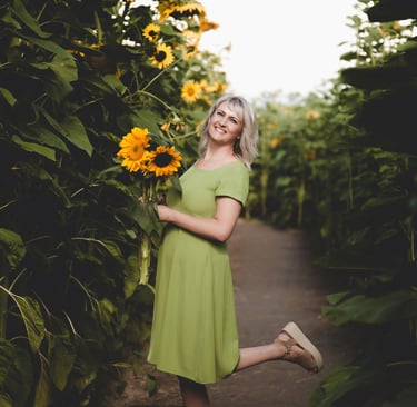 SEO founer of agency a woman in a green dress standing in a field of sunflowers