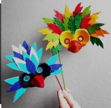 a person holding a paper flower with a bird on it