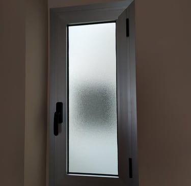 Ventana estrecha de aluminio para baño con cristal opaco instalada por Cristalería Ramsal.