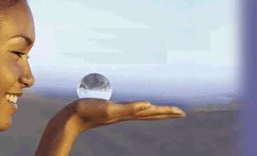 Partie d'un visage de femme. Elle tient dans sa paume de main 1 boule de cristal symbole hypnotique