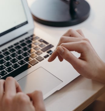 une personne tape sur un ordinateur portable
