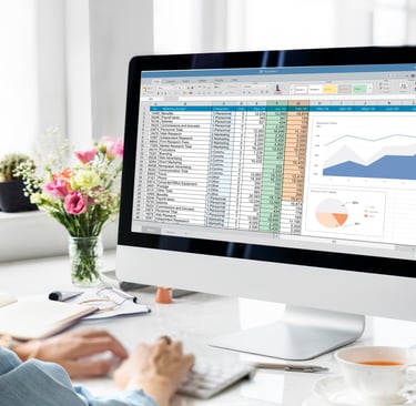 a person sitting at a desk with a computer monitor and a cup of coffee