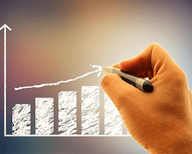 a hand holding a pen and writing on a white board