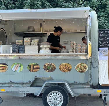 a man is standing in front of a food truck