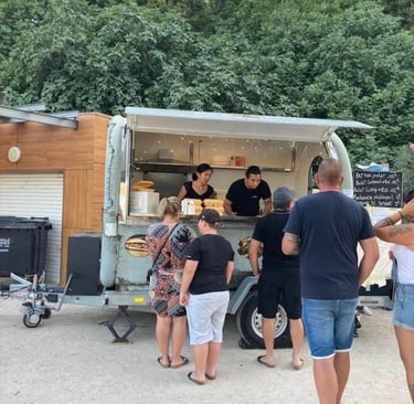 a group of people standing around a food truck