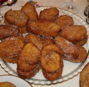 a plate of rabanada and a glass, food table
