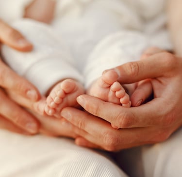 mains maman et papa qui soutiennent pieds bébé pour consultation sommeil complet sophie jobbé duval