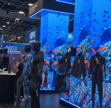 scuba dive mannequins in front of big convention columns showing  a dive video