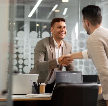 a man shaking hands with another man in a suit