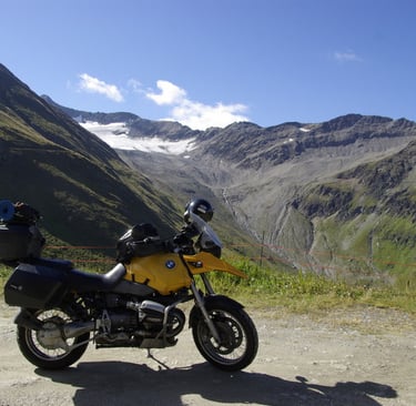 a motorcycle parked on alpin road near a mountain