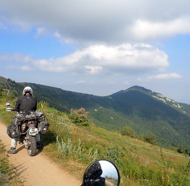 a person riding a motorcycle on a alpin dirt road