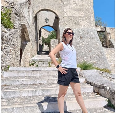 a woman standing on steps leading up to a stone building